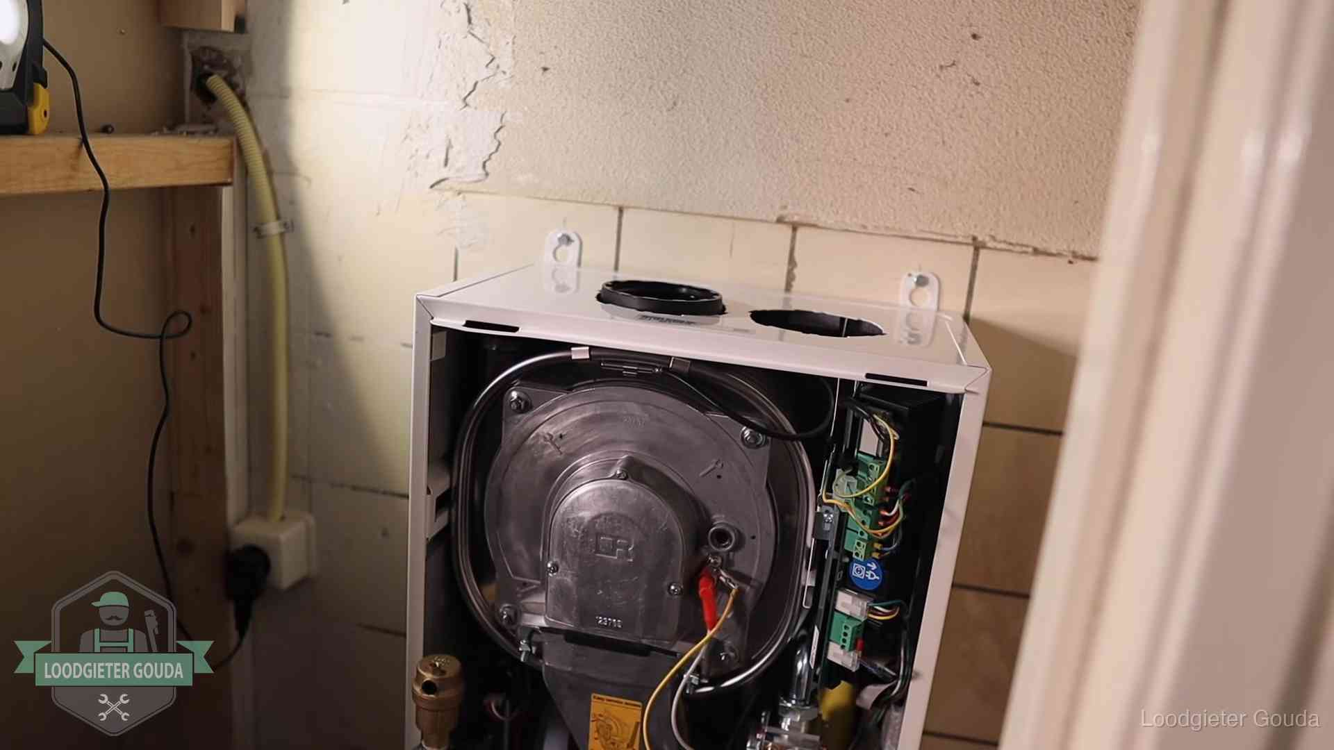 Geopende cv-ketel tijdens een onderhoudsbeurt in Gouda, met brander en warmtewisselaar zichtbaar