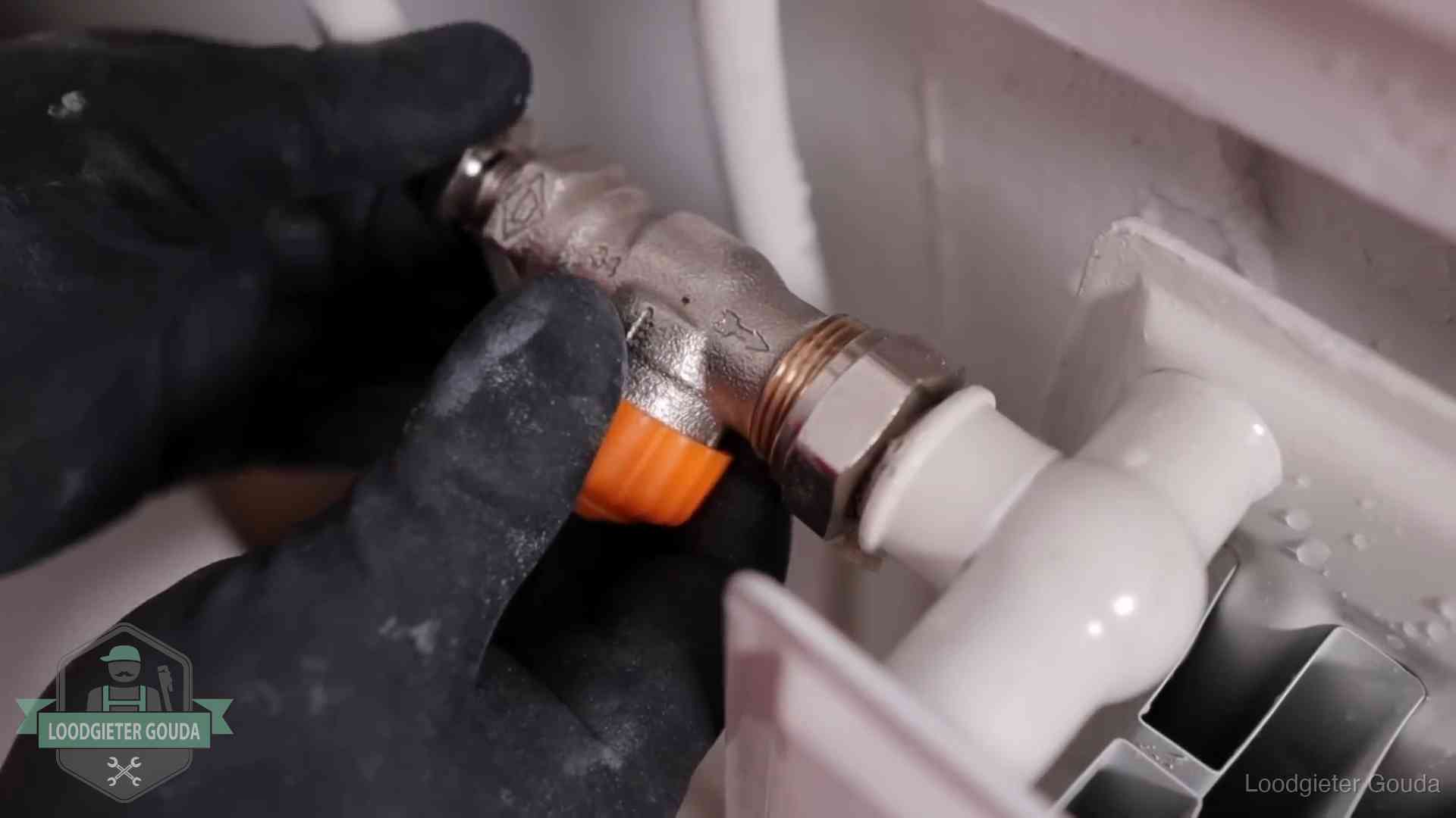 Thermostaatkraan wordt gemonteerd op een radiator in Gouda voor het stookseizoen