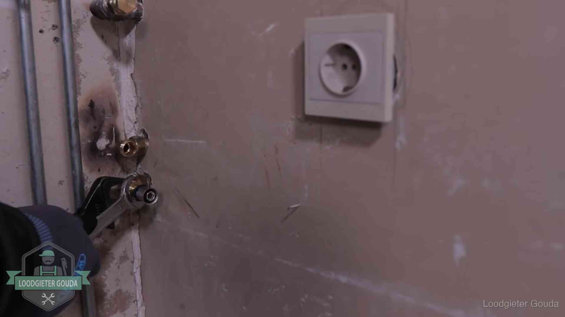 Monteur draait een perskoppeling vast op een leidingaansluiting in Gouda