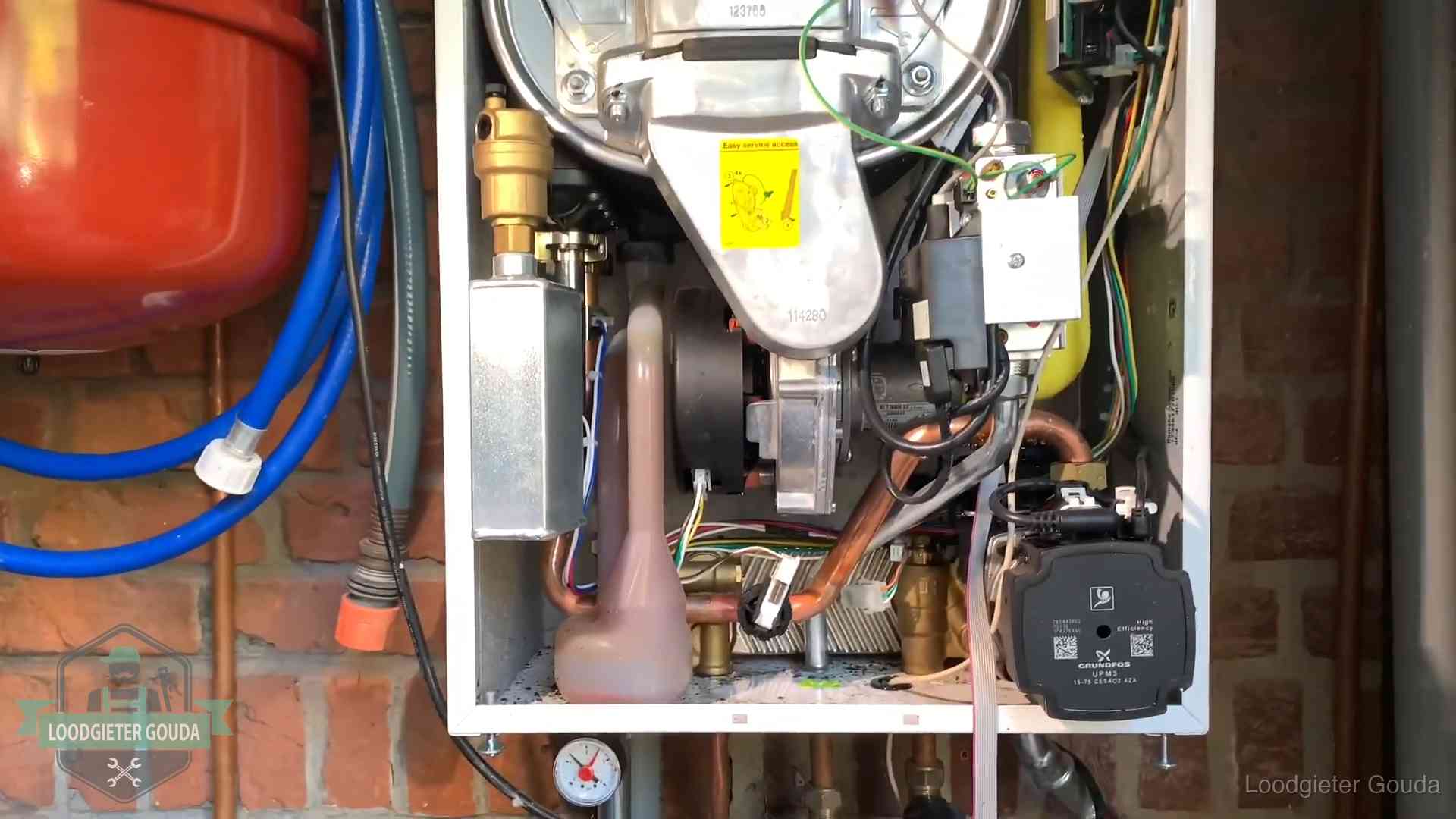 Geopende cv-ketel met rood expansievat in een woning in Gouda