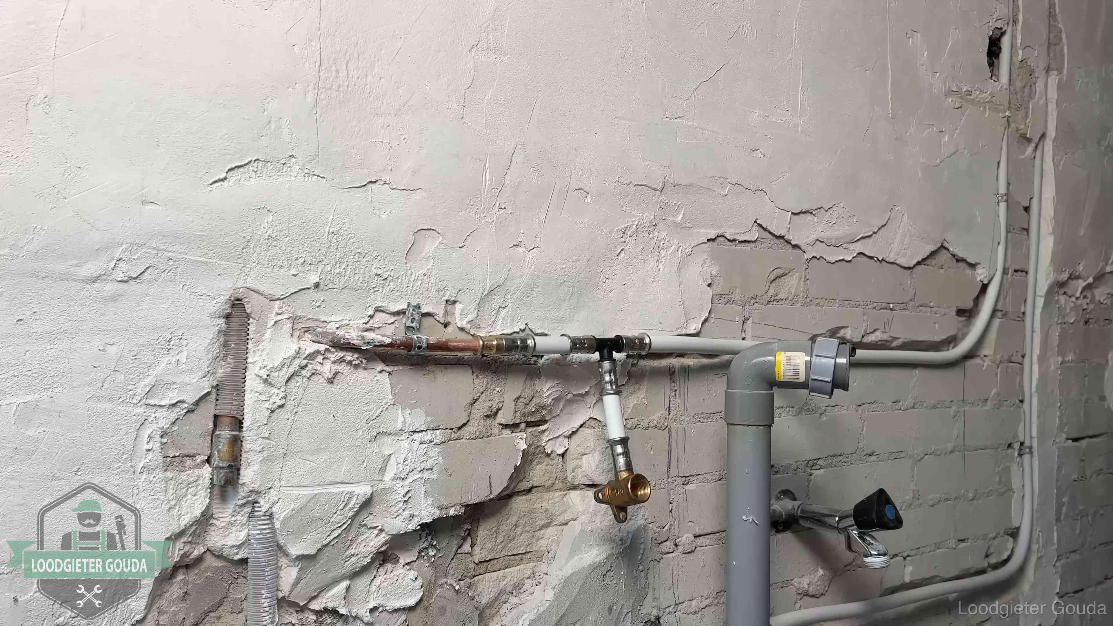 Nieuw leidingwerk naast een oud verroest leidingrestant in een woning in Gouda