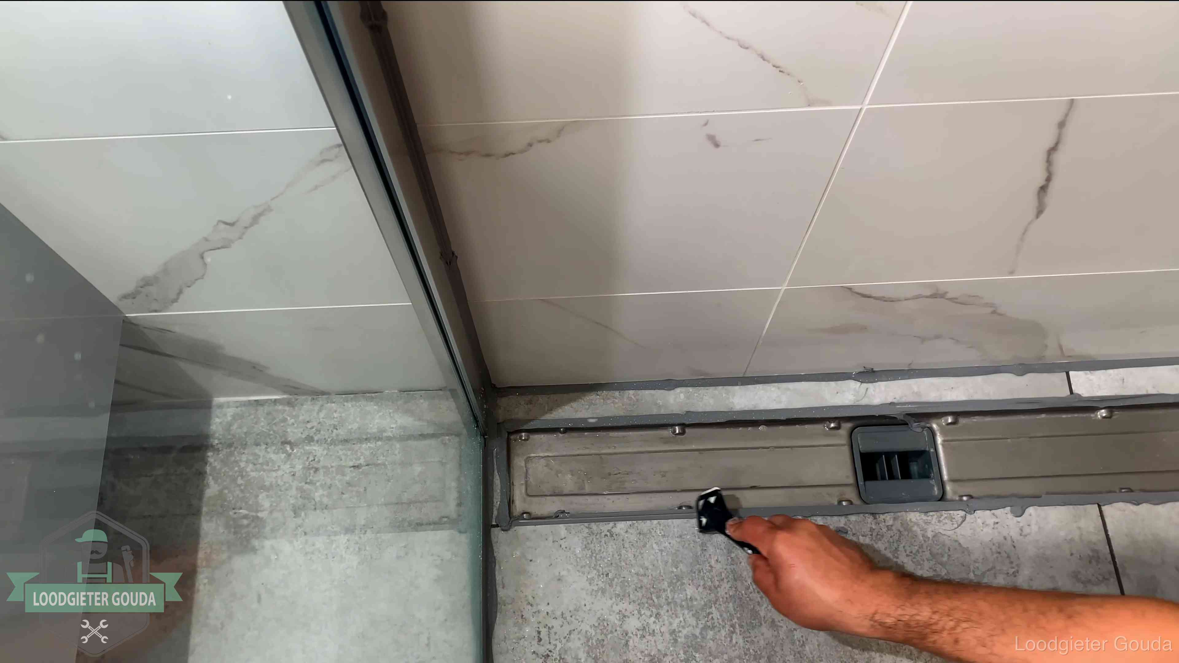 Lekkage in de badkamer verhelpen in Gouda Verse kitrand langs de douchegoot in een betegelde badkamer in Gouda