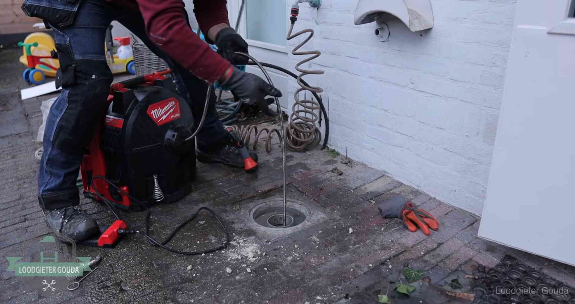 Erfgrens en gemeenteriool in Gouda Ontstoppingsputje in de bestrating naast de gevel van een woning in Gouda