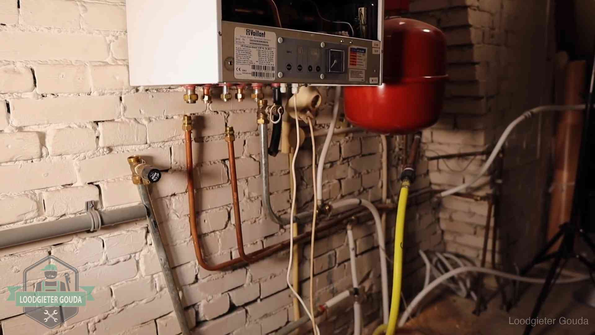 Verouderde cv-ketel met een wirwar van oude leidingen in een woning in Gouda