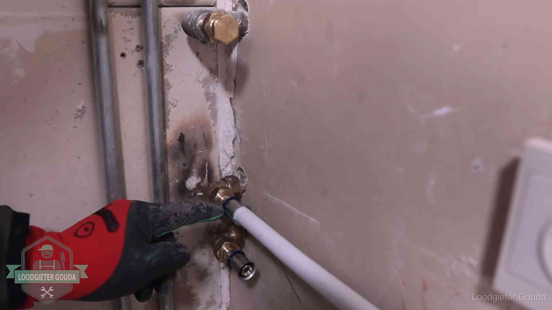 Loodgieter wijst de persfitting op nieuwe muuraansluitingen aan in een woning in Gouda
