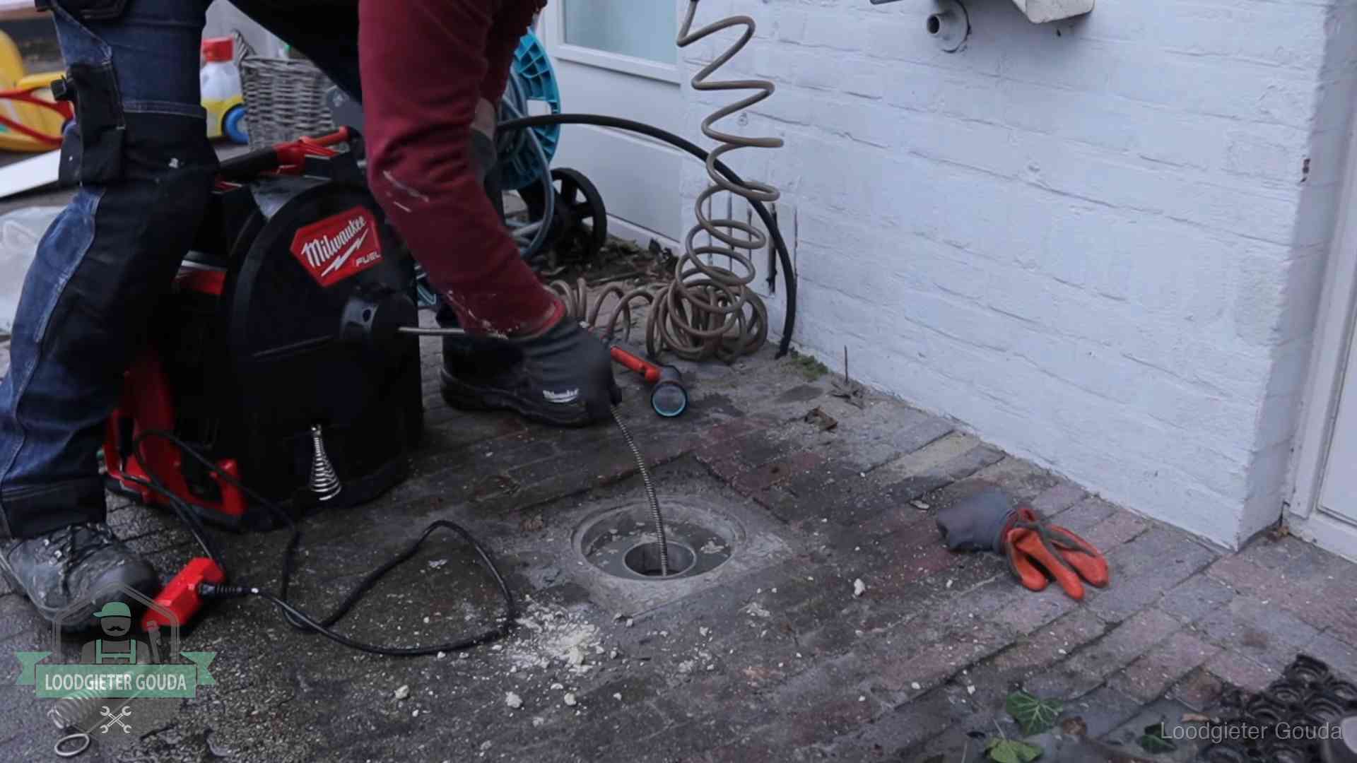 Prijs van een rioolontstopping in Gouda Spiraalmachine bij een ontstoppingsputje in de bestrating in Gouda
