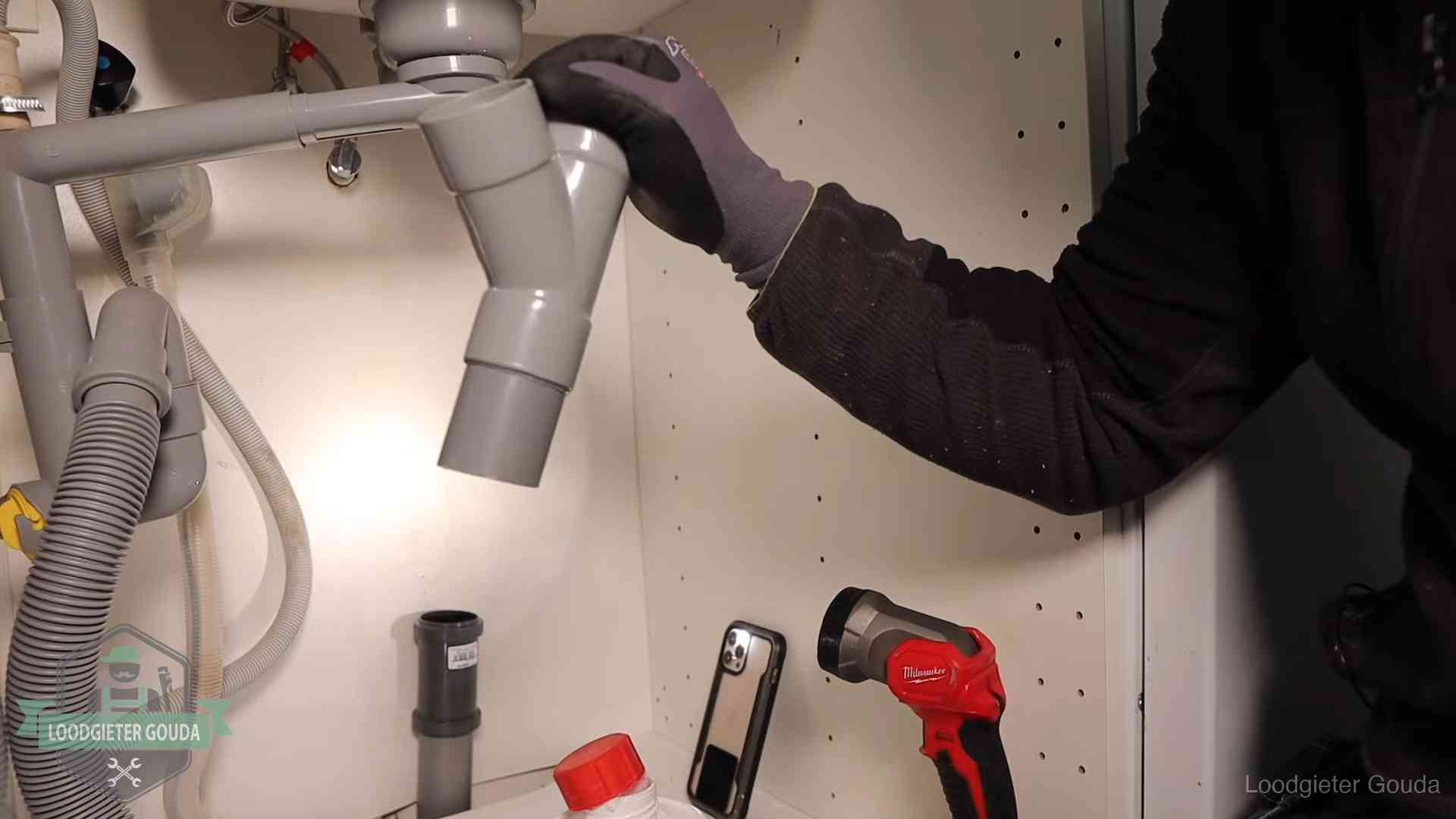 Rioollucht in huis verhelpen in Gouda Loodgieter demonteert het sifon- en afvoerwerk onder een gootsteen in Gouda bij stankklachten