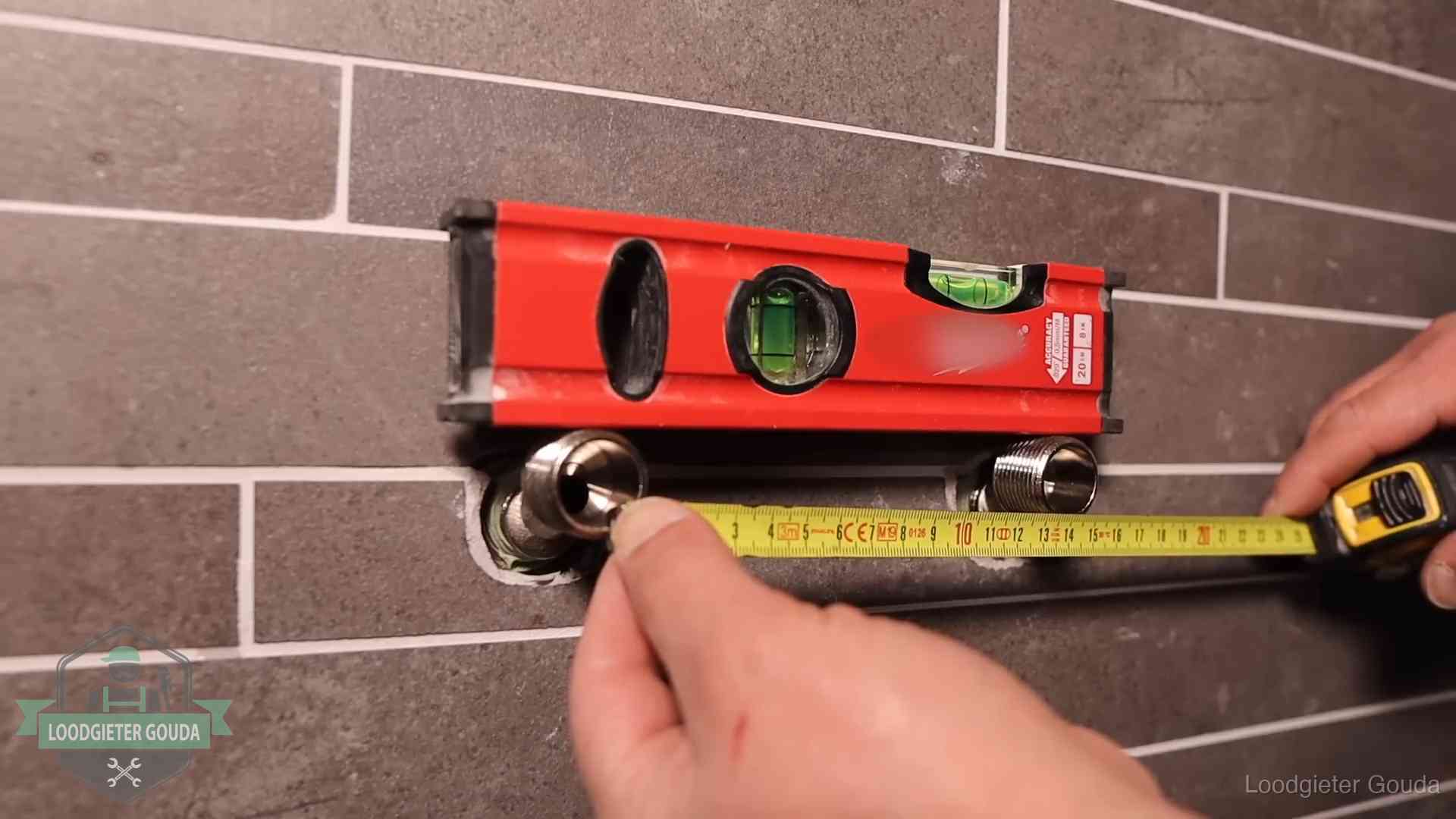 Waterpas en duimstok bij kraan-aansluitpunten in een badkamer in Gouda