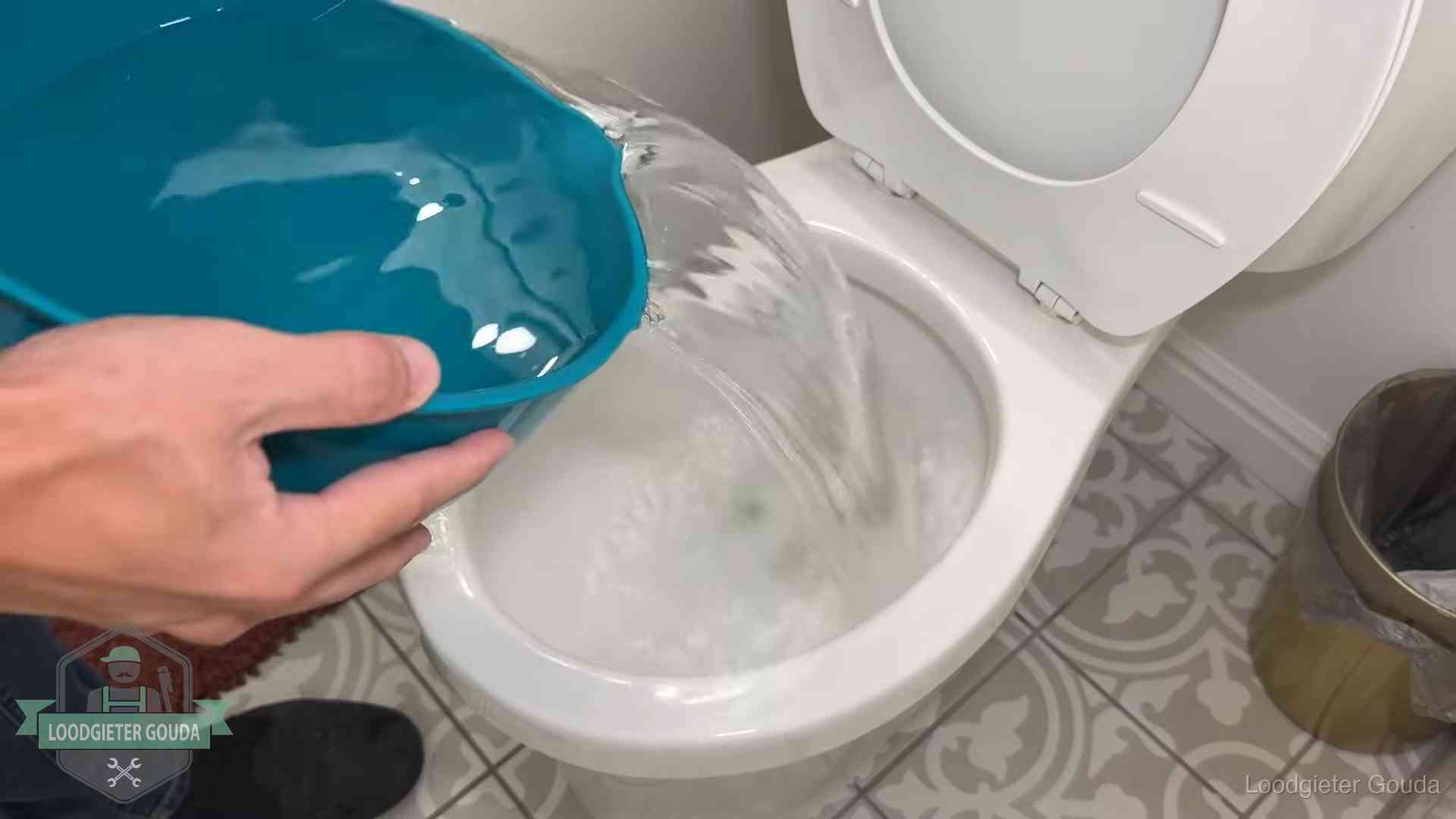 Warm water wordt voorzichtig in de wc-pot gegoten in Gouda