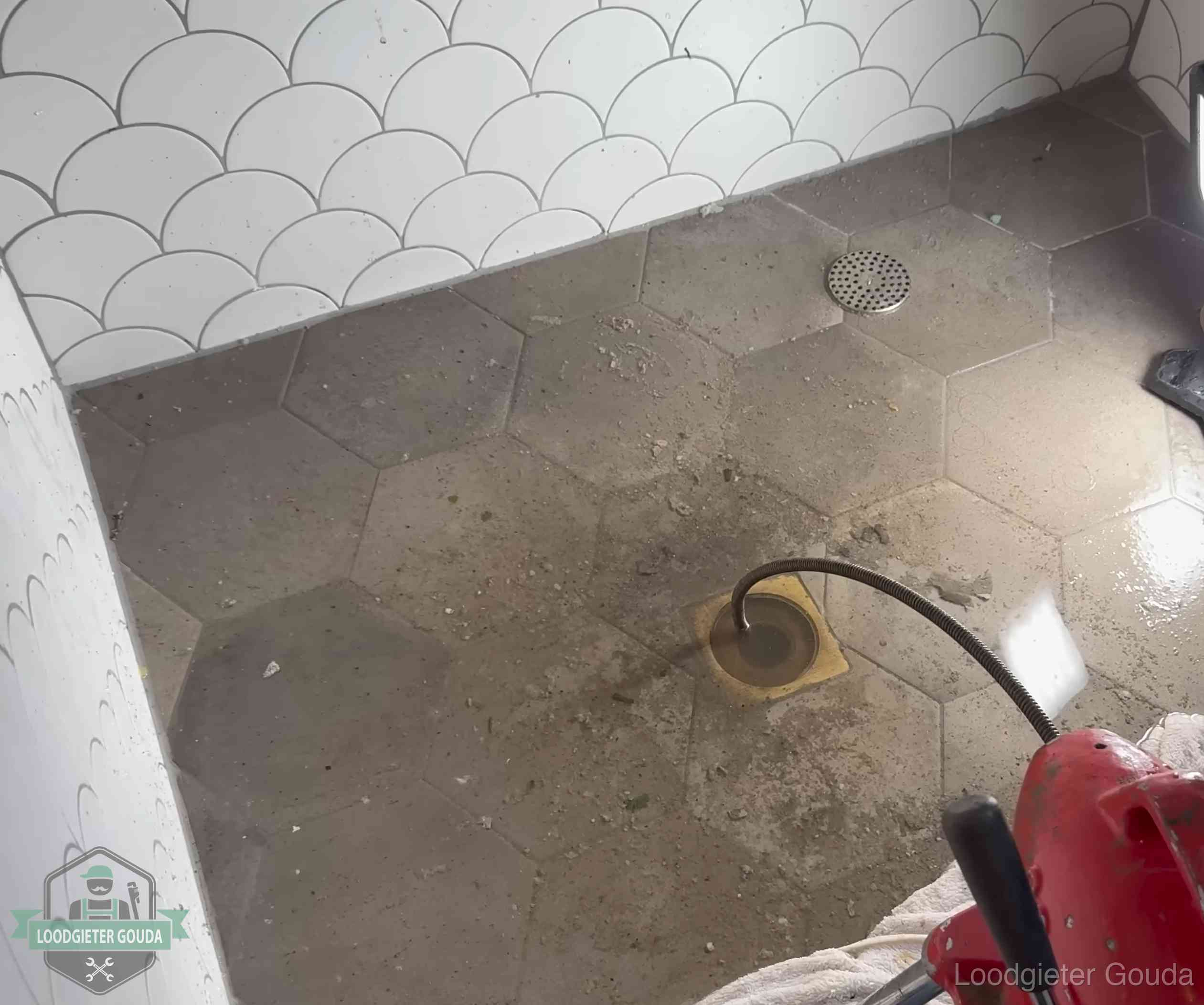 Vloerput met waterslot in een badkamer in Gouda, een bron van stank als het waterslot droogstaat