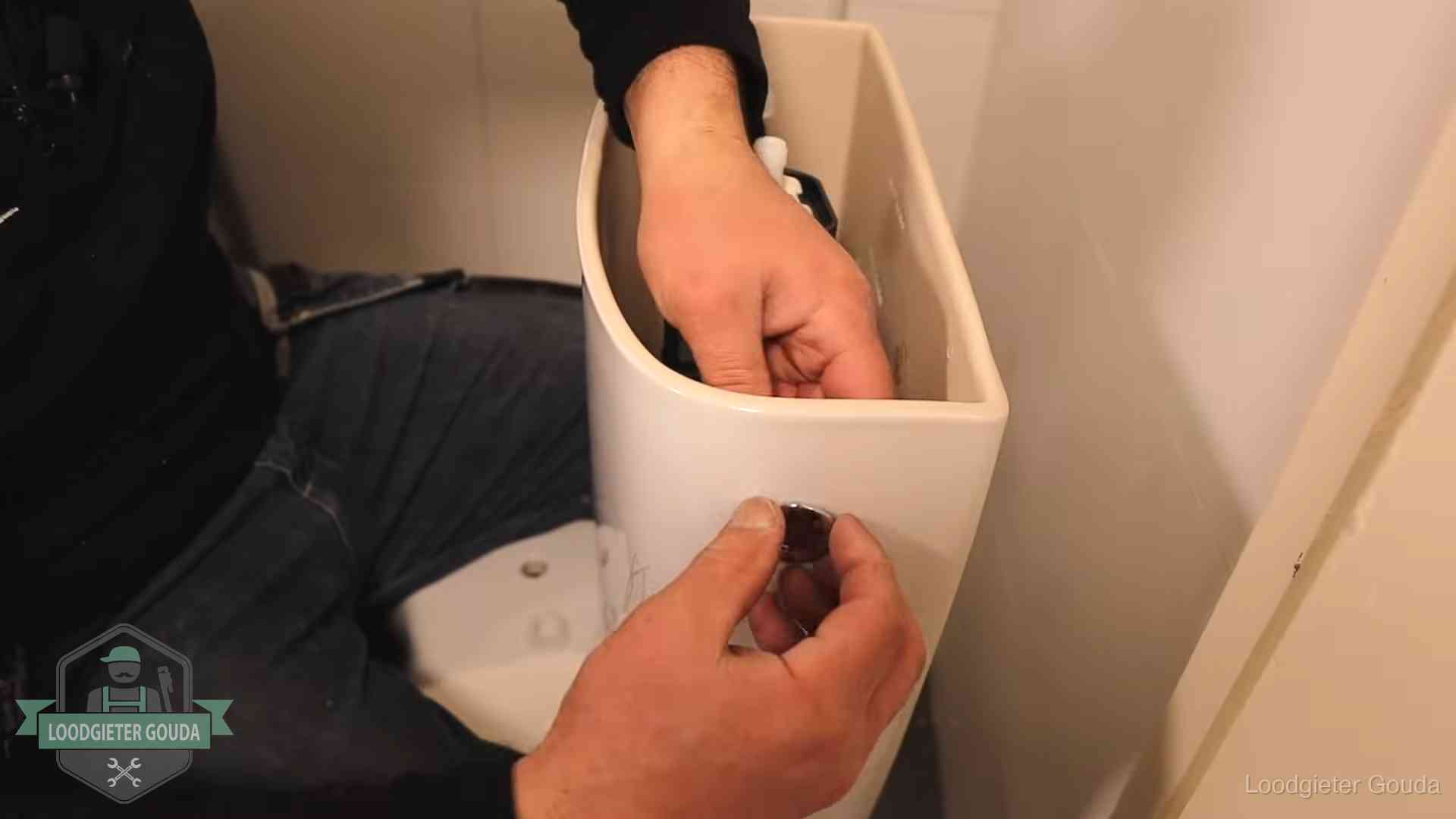 Drukknop van een duoblok-stortbak wordt gemonteerd bij een toilet in Gouda