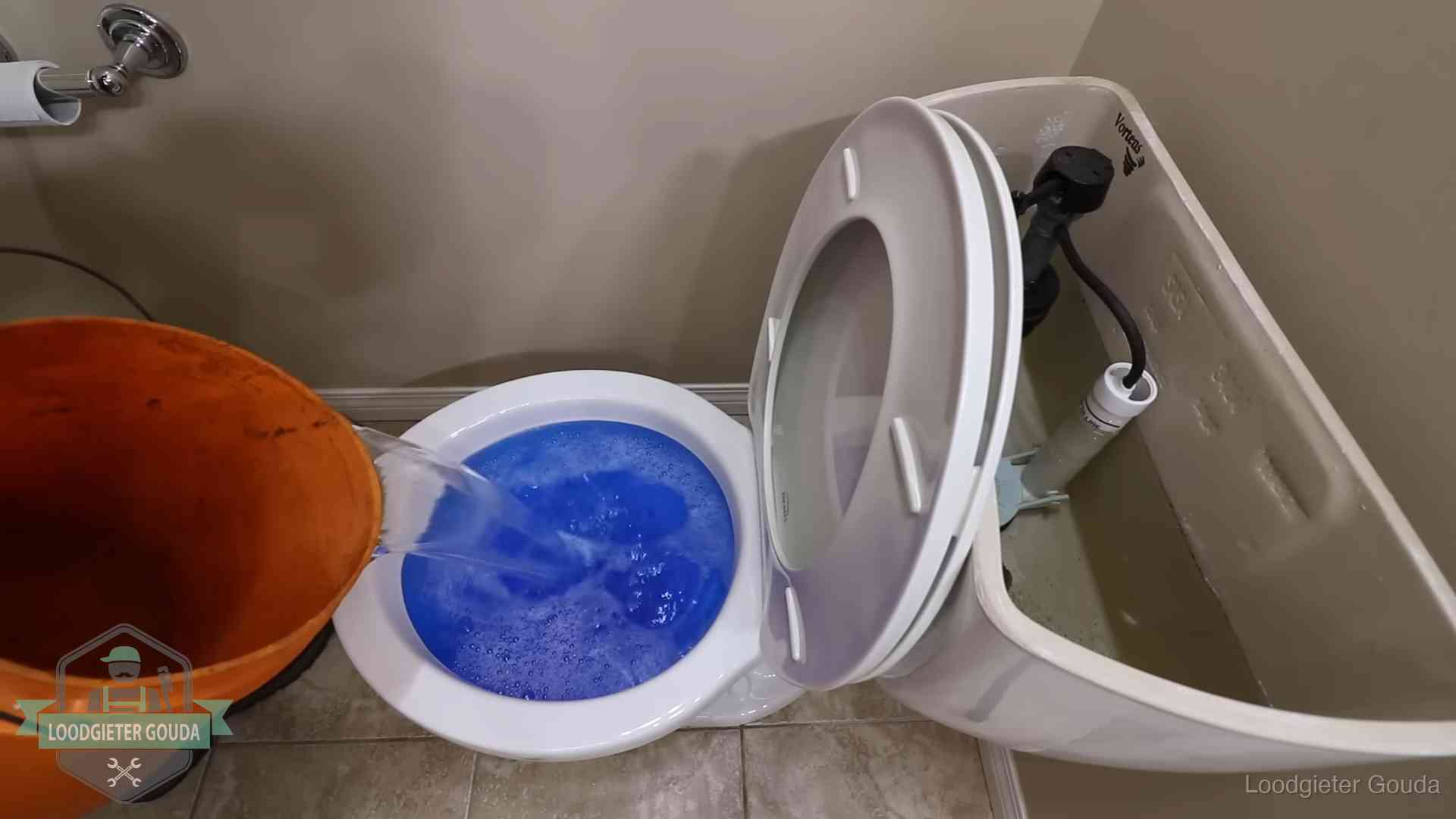 Water bij de wc-pot wordt met een emmer weggewerkt om schade te beperken in Gouda